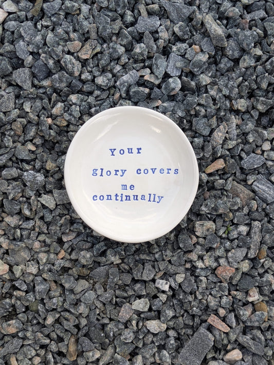 Your Glory Covers Me Continually round trinket tray – a handmade ceramic dish about 10.5cm wide, hand-stamped with the words “your glory covers me continually”, shown from above on grey stone chippings