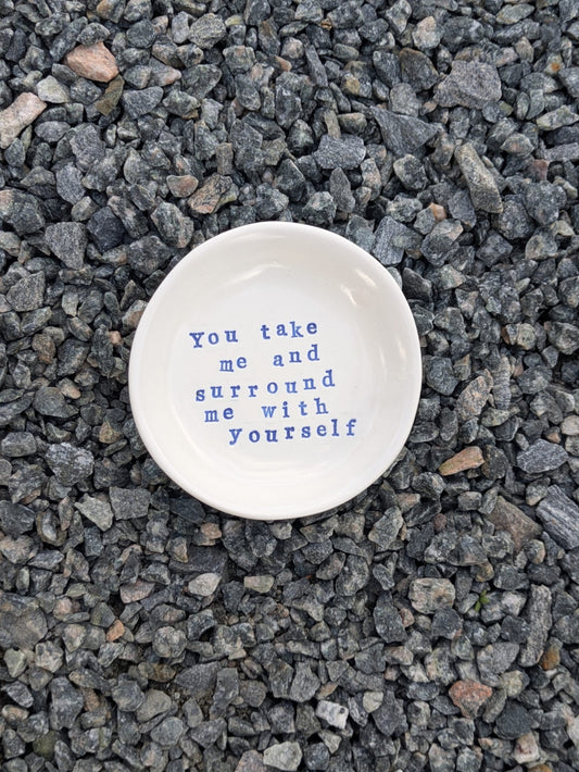 You Take Me And Surround Me With Yourself round trinket tray – a handmade ceramic dish about 10.5cm wide, hand-stamped with the words “you take me and surround me with yourself”, shown from above on grey stone chippings